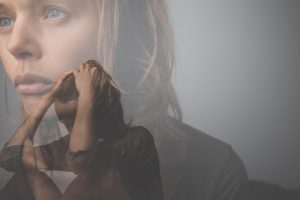 Depressed, anxious young woman facing harsh life situation, suffering from mental disorders, illness